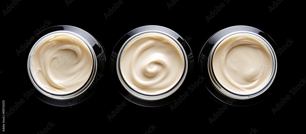 Poster A top view of three isolated face cream jars on a black background with copy space for an image