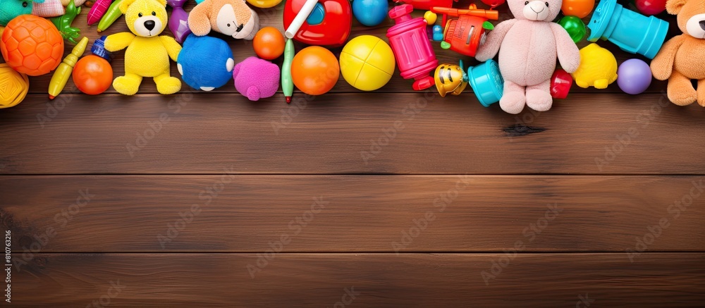 Poster A vibrant frame made of colorful kids toys is displayed on a wooden background as seen from a top view perspective The image is laid flat and provides ample space for text
