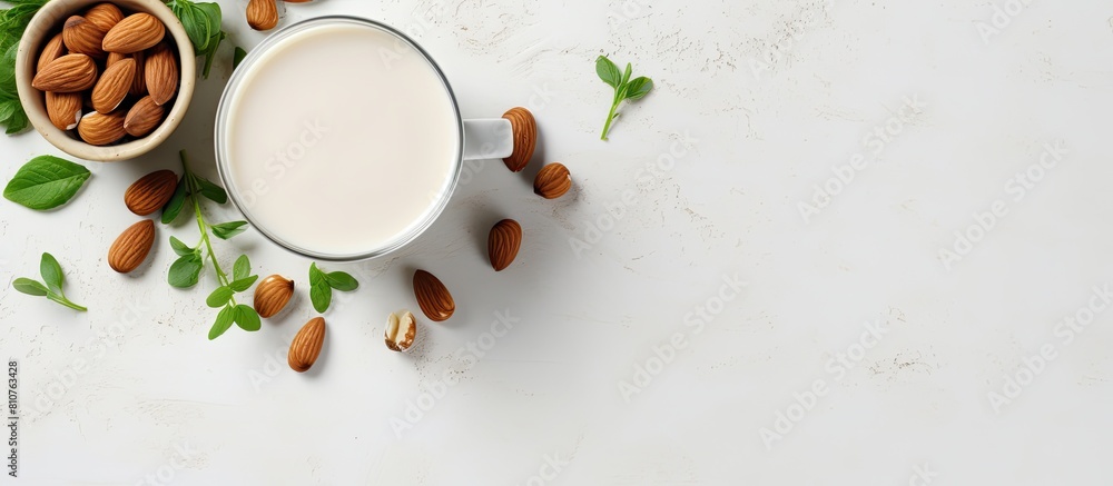 Aufkleber Top view of a cup filled with almond milk surrounded by nuts and a potted plant placed on a white concrete background This non dairy and vegan composition creates a visually appealing copy space imag