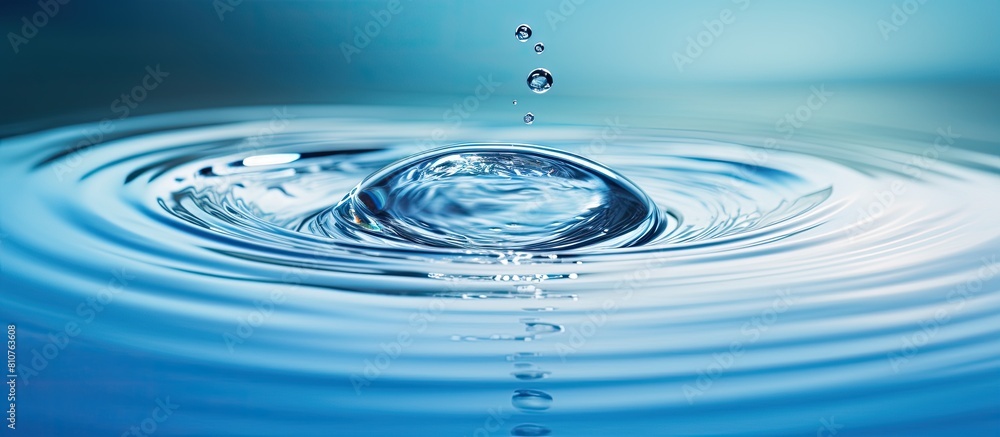 Fototapete a captivating image of a water droplet falling onto the water s surface creating a mesmerizing circu