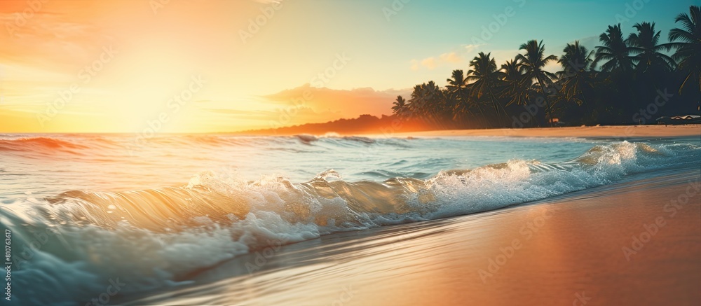 Poster blurry tropical sunset beach with the bokeh effect of sunlight on the waves creates an abstract back