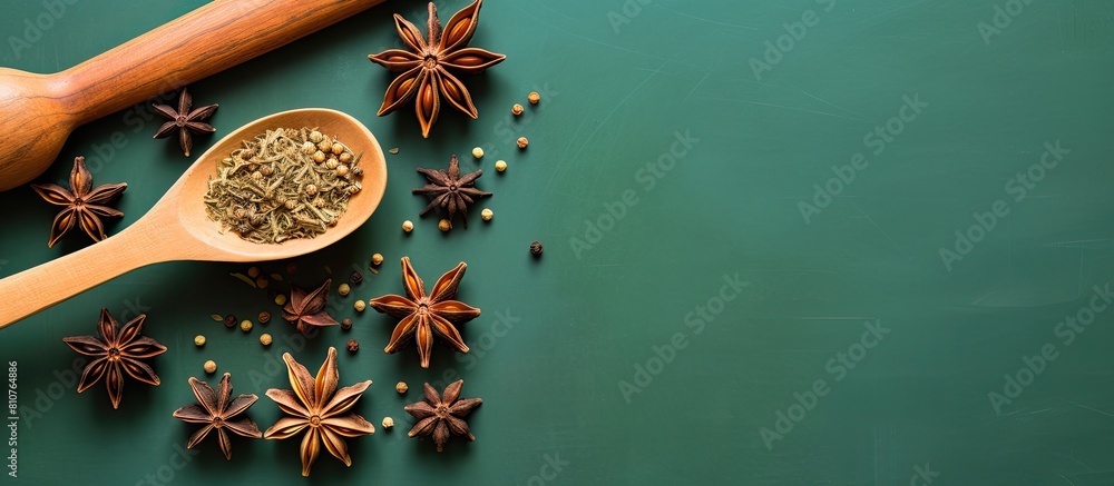 Poster a group of star anise with seeds is displayed on a green background along with anise in a wooden spo