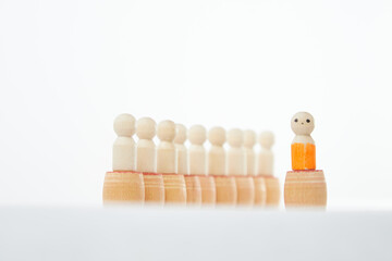 Wooden figurines with a leader and a group with partial focus. The concept of distinguishing a...