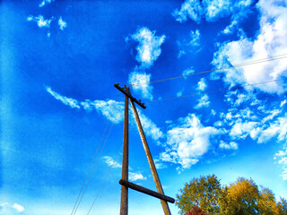 Old pole with wires against the sky. Electric transmission line. Eco-friendly energy