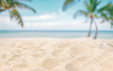 Abstract blurred defocused beach background, nature of tropical summer beach. Golden sand beach, sea water and palms against sky. Summer vacation concept.