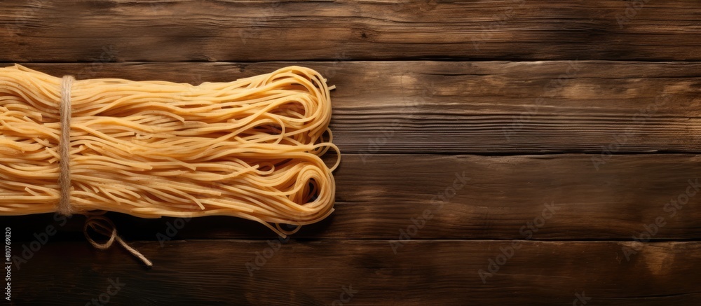 Poster A copy space image of spaghetti tied with twine sits atop a rustic wooden table viewed from above