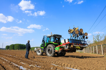 Obraz premium In spring, farmers use farm machinery to grow peanuts
