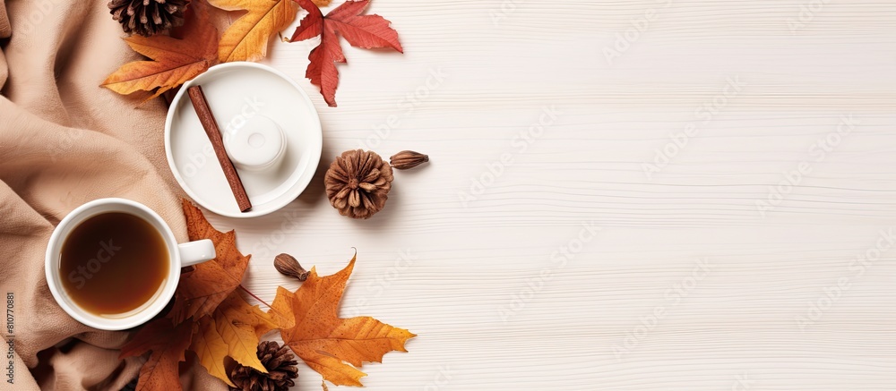 Poster a cozy autumn home composition with dried leaves a cup of coffee a book a scarf and flowers on a whi