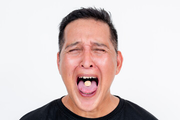 Middle-aged Asian man grimacing while taking bitter medicine, isolated on white