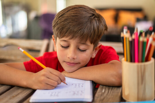 9 Year Old Boy Doing Math Exercises at Home. Home Education Concept. Back to School.