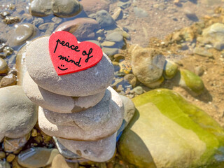 Peace of mind text on wooden heart shape with nature background.