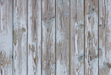Fototapeta premium An old fence with peeling paint, a wall of light, wooden boards in the background of a rural house. pastel wood, wall background Thanks to the use of wash, Creates a feeling of antiquity and beauty