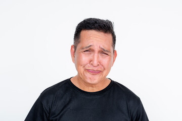 Middle-aged Asian man grimacing after tasting sour candy, isolated on white