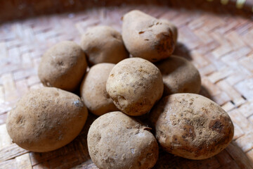 Freshly Harvested Potatoe on Woven Bamboo Tray, healthy food, stock photo.