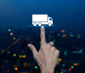 Hand pressing truck flat icon over blur colorful night light modern city tower and skyscraper, Truck transportation service concept