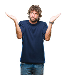 Handsome hispanic model man wearing winter sweater over isolated background clueless and confused...