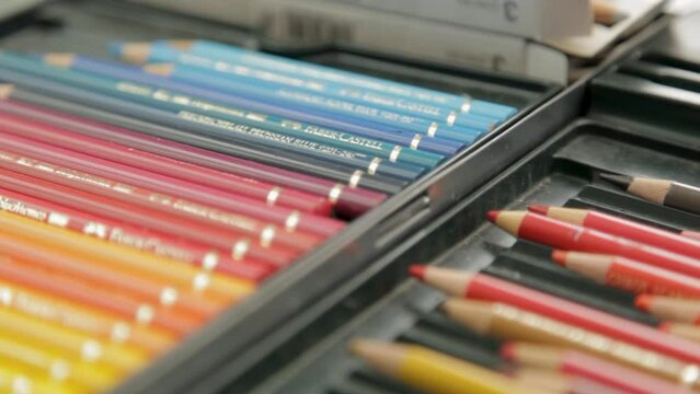 Close-up of an open colored pencil case with pencils arranged in gradient order