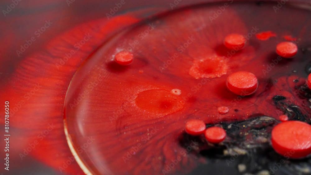 Poster close-up of vibrant red ink dispersing in water, creating abstract patterns