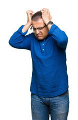 Fototapeta premium Middle age arab man wearing glasses over isolated background suffering from headache desperate and stressed because pain and migraine. Hands on head.