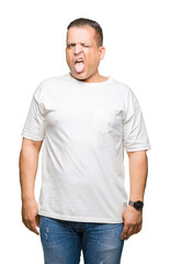 Middle age arab man wearig white t-shirt over isolated background sticking tongue out happy with funny expression. Emotion concept.