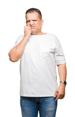 Middle age arab man wearig white t-shirt over isolated background looking stressed and nervous with hands on mouth biting nails. Anxiety problem.