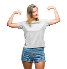 Fototapeta premium Young beautiful woman over isolated background showing arms muscles smiling proud. Fitness concept.
