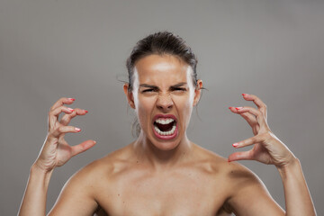 Furious young woman screaming with rage, depicting strong emotions and feelings of anger and frustration