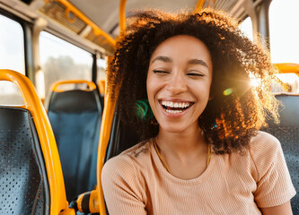 Young woman laughing and winking while sitting on a bus