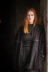 Portrait of a young beautiful red-haired girl in a low key.