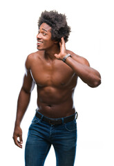 Afro american shirtless man showing nude body over isolated background smiling with hand over ear listening an hearing to rumor or gossip. Deafness concept.