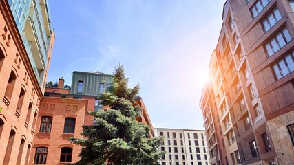 Modern residential building with new apartments in a green residential area. Eco architecture. Green tree and new apartment building. The harmony of nature and modernity.