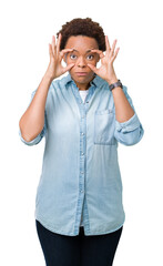Fototapeta premium Young beautiful african american woman over isolated background Trying to open eyes with fingers, sleepy and tired for morning fatigue