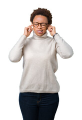 Fototapeta premium Young beautiful african american woman wearing glasses over isolated background covering ears with fingers with annoyed expression for the noise of loud music. Deaf concept.