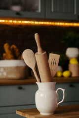 Wooden kitchen utensils in a jug on the table