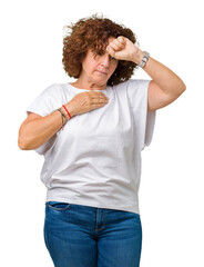 Beautiful middle ager senior woman wearing white t-shirt over isolated background Touching forehead for illness and fever, flu and cold, virus sick