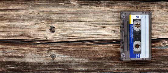 Banner of Retro cassette tape on a brown wooden surface.