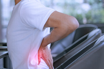 Close-up of a man with severe back pain after sitting for a long time.