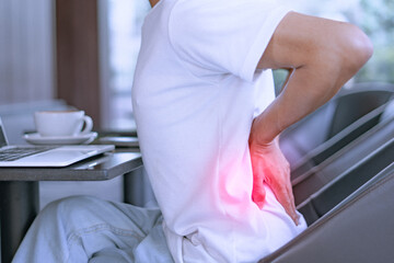 Close-up of a man with severe back pain after sitting for a long time.