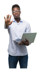 Young african american businessman using computer laptop with open hand doing stop sign with serious and confident expression, defense gesture