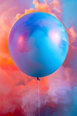 Close-up of a shiny blue balloon with bright reflections and a surreal pink and blue smoky...
