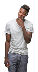 Young african american man over isolated background with hand on chin thinking about question, pensive expression. Smiling with thoughtful face. Doubt concept.