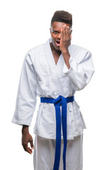 Young african american man over isolated background wearing kimono covering one eye with hand with confident smile on face and surprise emotion.