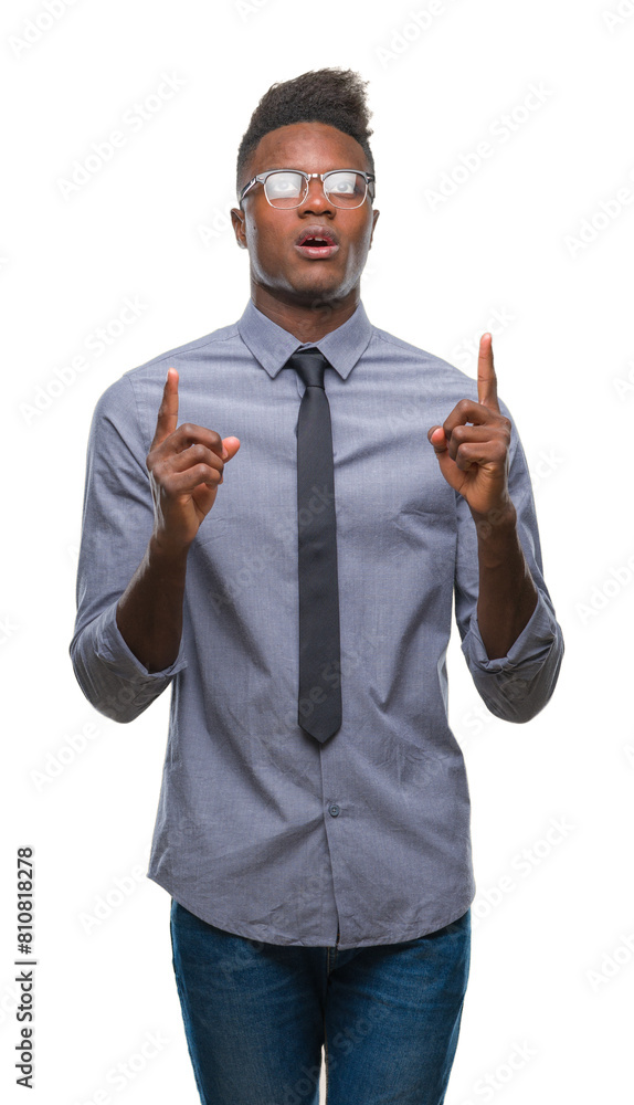 Poster Young african american business man over isolated background amazed and surprised looking up and pointing with fingers and raised arms.