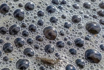 Close-up shot of foam bubbles by the lake shore