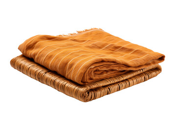 A yellow and brown striped blanket is on top of a brown wicker basket. The blanket is folded neatly and is placed on a white background