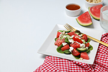 Watermelon salad in a square bowl on a white background