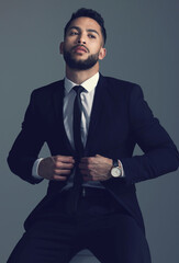 Confident businessman, fashion and suit in formal attire or clothing on a dark studio background. Handsome man, young employee or model in stylish outfit, tie and ready in business or career ambition