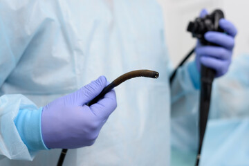 Instruments for diagnostic endoscopy close-up. The doctor holds a flexible endoscope in his hands....