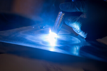 Close-up of tig welding process on metal surface with bright blue arc light