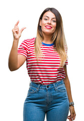 Young beautiful woman casual look over isolated background smiling and confident gesturing with hand doing size sign with fingers while looking and the camera. Measure concept.